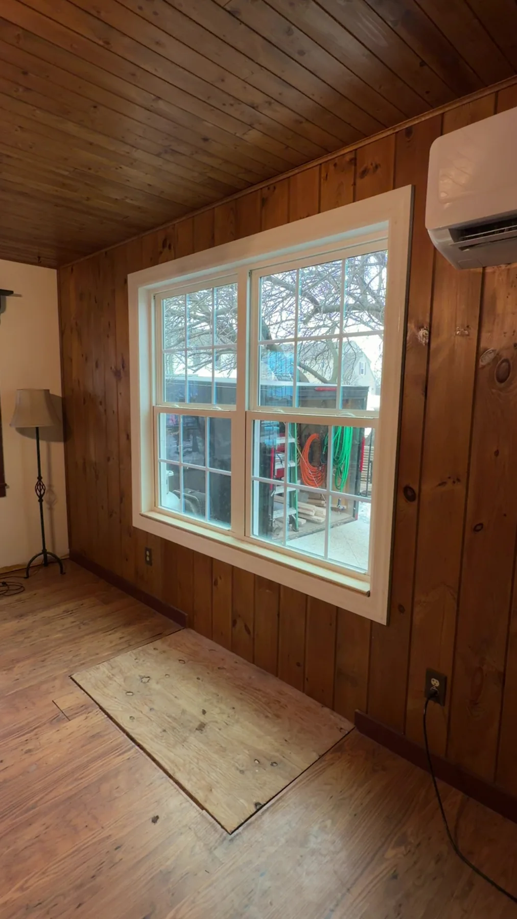 Replacement window installed in a wood-paneled room